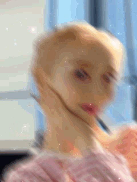 a blurry picture of a woman 's face with her hand on her face