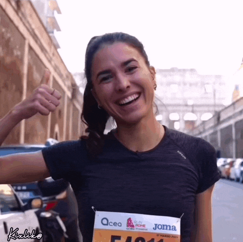 a woman is wearing a joma shirt and smiling