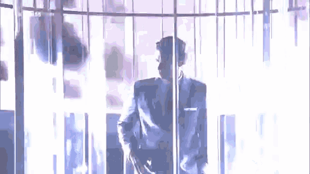 a man in a suit and tie is standing in front of a screen that says tcm