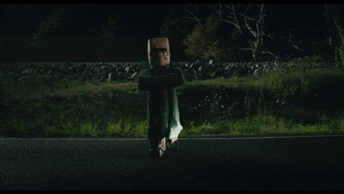 a car is driving down a road at night with a person flying in the air