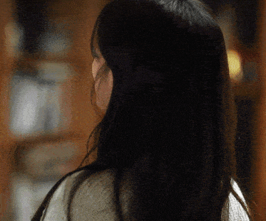 the back of a woman 's head with long black hair