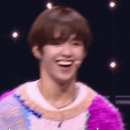 a close up of a person laughing on a stage with a microphone .
