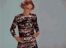 a woman in a sequined dress is dancing in a room .
