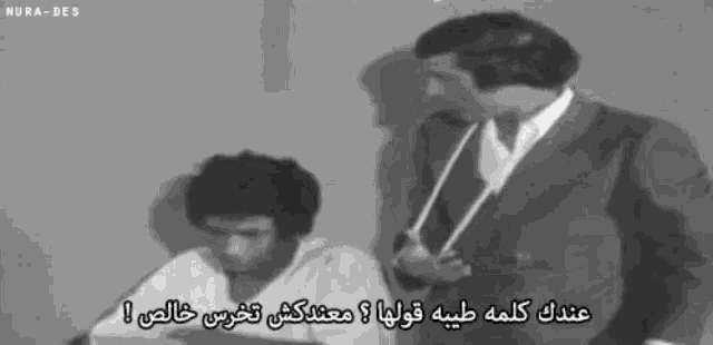 a black and white photo of two men with arabic writing