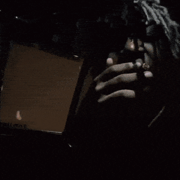 a man is smoking a cigarette in a car while driving at night .