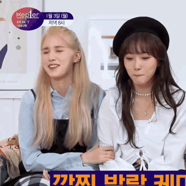 two girls are sitting next to each other in front of a sign that says " kepler debut show "