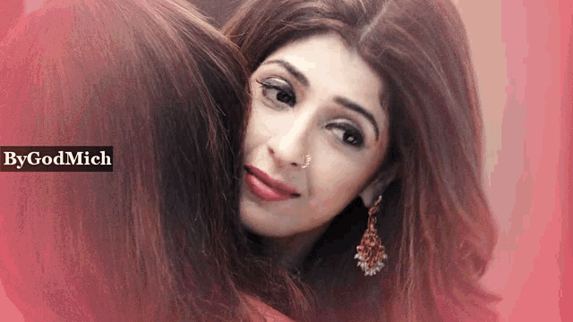 a woman with a nose ring is hugging another woman with bygodmich written on the bottom