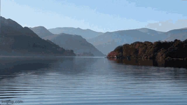 a lake with mountains in the background and the website imgflip.com