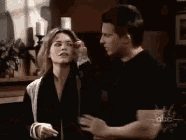 a man and woman are standing next to each other in a living room .