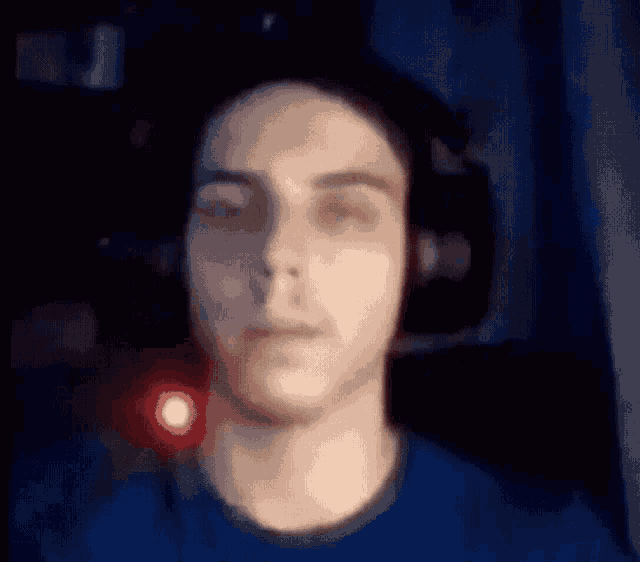 a blurry picture of a man wearing headphones and a blue shirt .