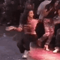 a group of people are dancing on a red carpet in a club .