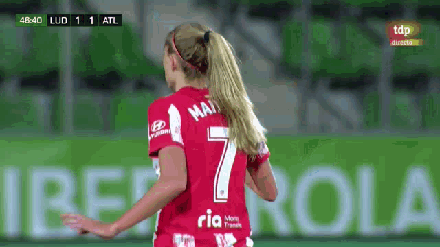 a woman in a red jersey with the number 7 on the back