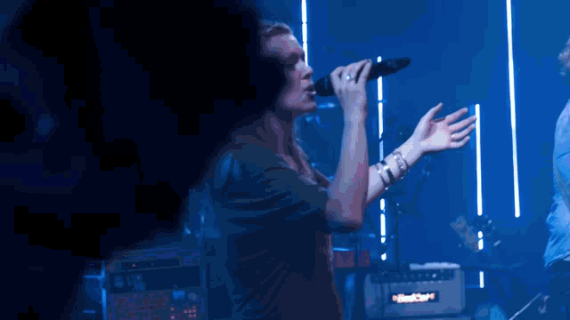 a man singing into a microphone in front of a mixer that says nitrofury