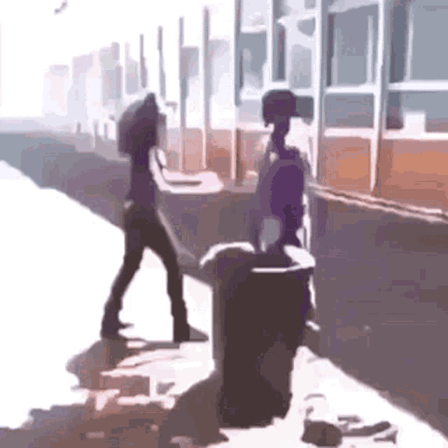 a man and a woman are standing next to each other on the sidewalk .
