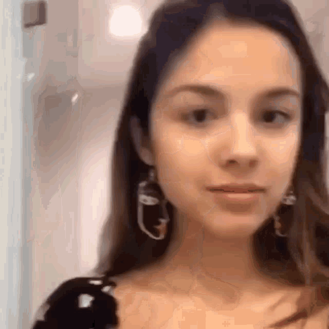 a close up of a woman wearing earrings .