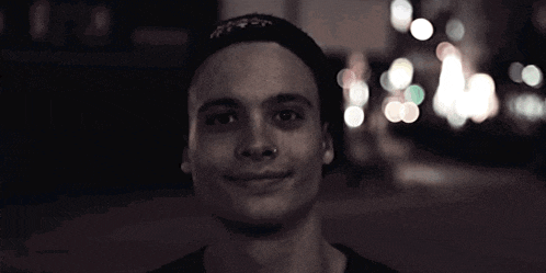 a man with a nose ring is smiling in a blurry photo