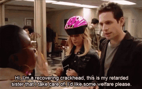 a woman wearing a pink helmet talks to a man in a hospital