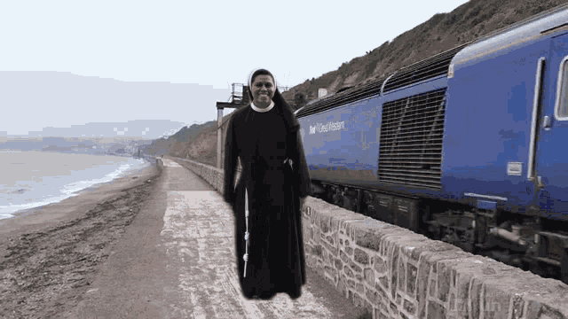 a man in a black robe is standing next to a blue train that says great western on the side
