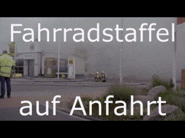 a man in a yellow vest stands in front of a building that says fahrradstaffel auf anfahrt