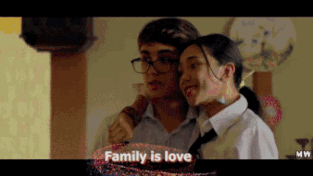a man and a woman are standing next to each other and the words family is love are on the screen
