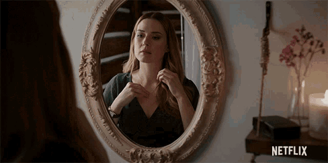 a woman looking at herself in a mirror with a netflix logo on the bottom