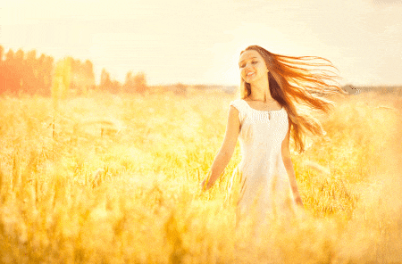 a woman in a white dress is walking through a field of tall grass