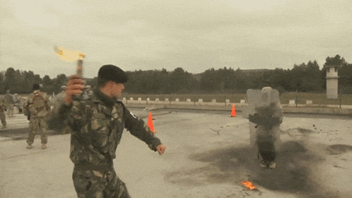 a man in a military uniform is holding a flamethrower in his hand