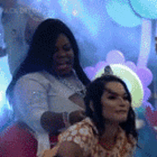 two women are posing for a picture in front of balloons