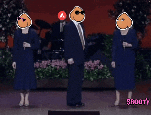 a man in a suit and tie stands in front of two women in blue dresses and a sign that says booty