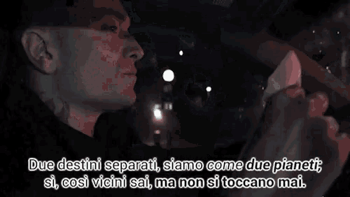a man is holding a piece of paper in his hand and says due destini separati , siamo come due pianeti