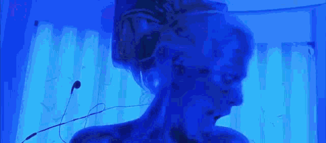 a person is swimming in a pool with a blue light behind them .