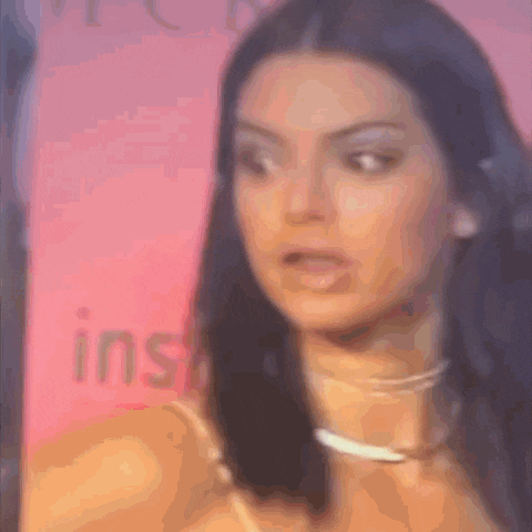 a close up of a woman 's face with a pink background