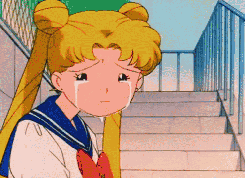 a girl in a sailor suit is crying on a set of stairs