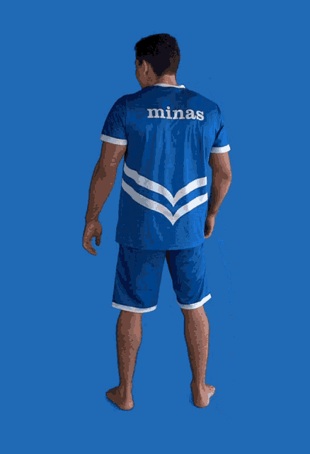 a man wearing a blue shirt with the word minas on the back