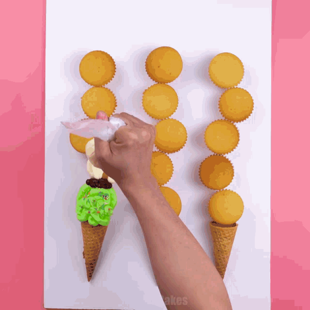 a person is decorating cupcakes that look like ice cream cones with frosting