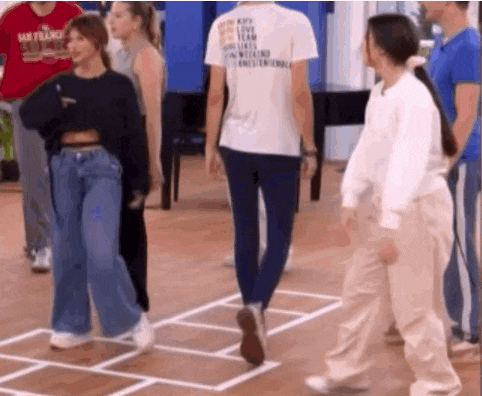 a group of people are standing in a room playing a game .
