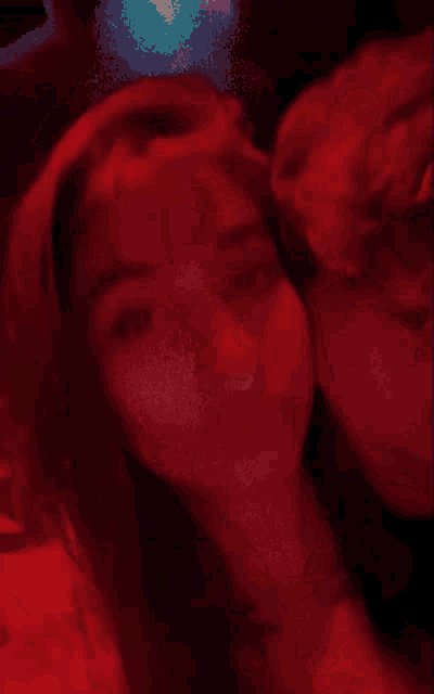 a blurry picture of a man and a woman in a red room