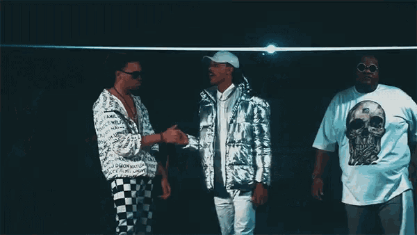 two men are standing next to each other with one wearing a silver jacket