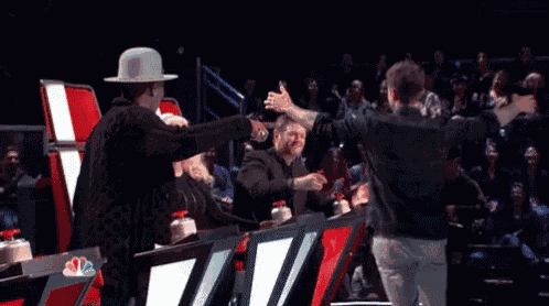 a man is hugging another man while sitting in a red chair .