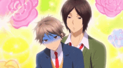 a couple of anime boys are standing next to each other .