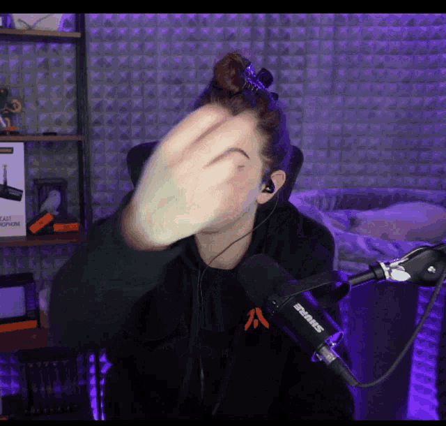 a man wearing headphones and a shure microphone covers his face