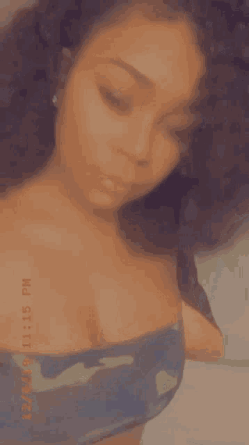 a woman with curly hair is taking a selfie with her eyes closed .