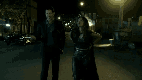 a man and a woman holding guns in a dark alleyway