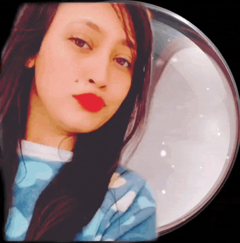 a woman with red lipstick and a mole on her nose looks at the camera