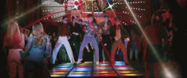 a group of people are dancing on a dance floor in a club