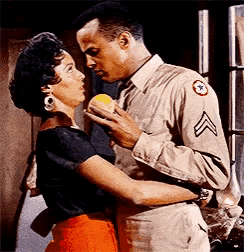 a man in a military uniform holds a woman in his arms