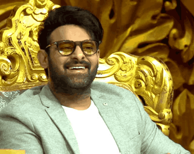 a man with glasses and a beard is smiling