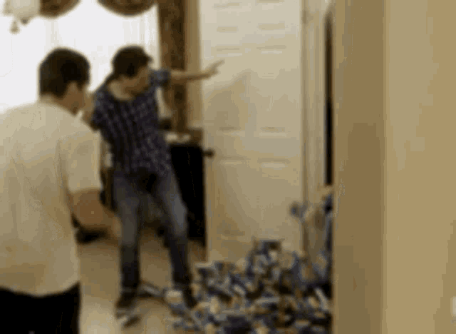 a man is standing in a room with a bunch of boxes on the floor .