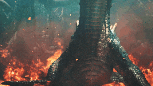 a large animal is laying on the ground with flames surrounding it