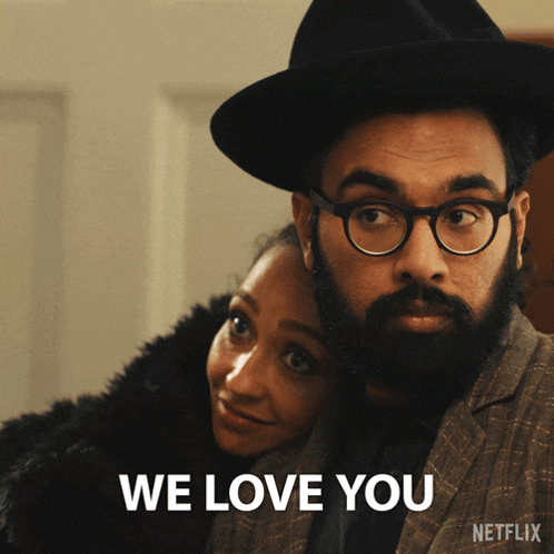 a man with a beard and glasses is hugging a woman with the words we love you on the bottom